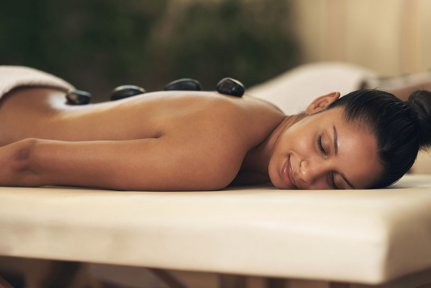 Hot-Stone-Massage am Rücken mit warmen Basaltsteinen