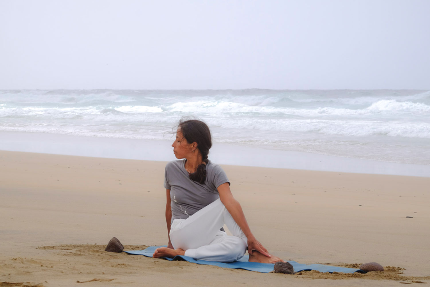 Frau macht Yoga am Strand