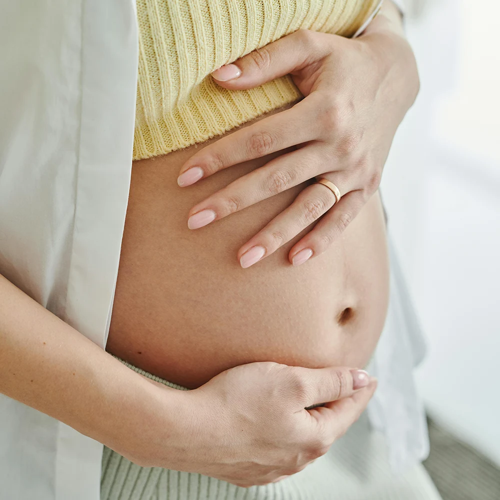 Schwangere Frau hält schützend den Bauch